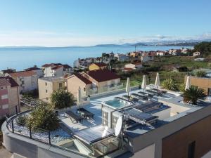 a view of a building with a swimming pool and the ocean at Villa Unique 9 in Podstrana