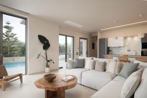 ハニア・タウンにあるAthina Luxury Villa, with Pool & Walk to the Beach, By ThinkVillaの白いソファとテーブルのあるリビングルーム