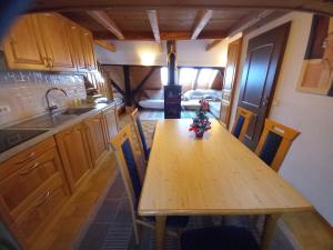 a kitchen with a wooden table with chairs and a sink at Apartments Tubej - Resort with wellness in Bohinj