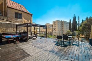 een houten terras met een tafel en stoelen erop bij Private House 5 BDR In Mamilla up to 12 People ! in Jeruzalem