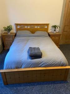 a bed with a wooden frame with a towel on it at Newcastle Apartment 3 - Free Parking in Old Walker