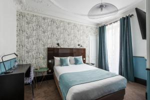 Schlafzimmer mit einem Bett, einem Schreibtisch und einem Fenster in der Unterkunft Lennon by Avalon Hotel Paris Gare du Nord in Paris