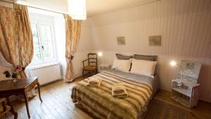 a bedroom with a bed with two towels on it at Ferme des Prades in Landeyrat