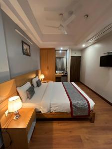 a bedroom with a large bed and a television at Hotel Sarvin in Lucknow