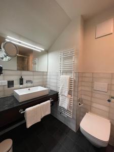 a bathroom with a sink and a toilet at Logis Hotel QUARTIER 5, Sächsische Schweiz, mit Restaurant, Café & Bar in Kurort Gohrisch