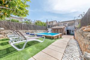 un patio trasero con piscina y tumbonas en Casa Juavert by Mallorca House Rent en Felanitx