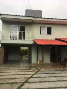 een huis met een rood dak en een balkon bij Casa para temporada Florianópolis in Florianópolis