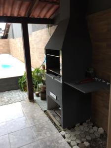 een zwarte barbecue op een patio met een zwembad bij Casa para temporada Florianópolis in Florianópolis