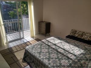 a bedroom with a bed and a dresser and a window at Casa para temporada Florianópolis in Florianópolis