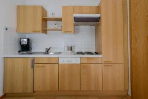 una cocina con armarios de madera y fregadero en Haus Gebhard en Reutte