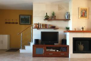 sala de estar con TV y chimenea en Superbe vue sur la baie de La Azohía en Cartagena