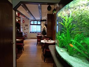 a restaurant with a fish tank in the middle of the room at Hotel An der Karlstadt in Bremerhaven