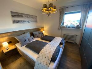 a bedroom with a large bed and a chandelier at Ferienwohnung Hochgratglück in Oberreute