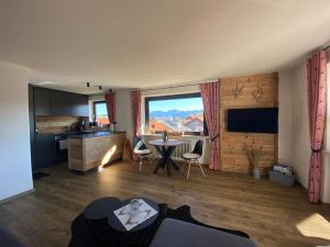 a living room with a table and a large window at Ferienwohnung Hochgratglück in Oberreute