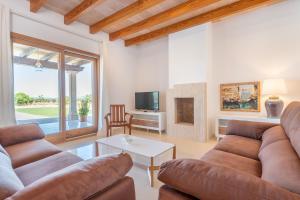 ein Wohnzimmer mit einer Couch und einem Tisch in der Unterkunft Finca Sa Era by Mallorca House Rent in Felanitx