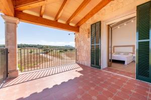eine Außenterrasse mit einem Bett und einem Balkon in der Unterkunft Finca Sa Era by Mallorca House Rent in Felanitx + 30 Fotos