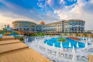 a resort with a pool and chairs and buildings at Arnor De Luxe Hotel & Spa in Side