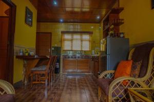 a kitchen with a refrigerator and a table and chairs at Anse Kerlan Beach Chalets in Anse Kerlan