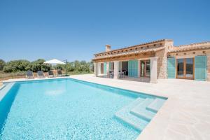 a villa with a swimming pool in front of a house at Finca Sa Vinya by Mallorca House Rent in Felanitx