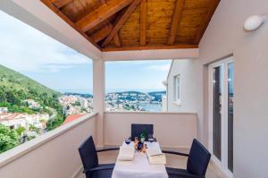 uma varanda com uma mesa e cadeiras com vista em Apartments Villa Dadić em Dubrovnik