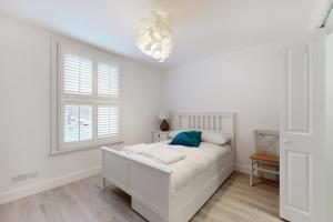 um quarto branco com uma cama e uma janela em Beautiful 3 bed house 30 mins from Central London em Kingston upon Thames