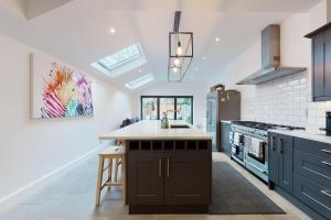una cocina con armarios azules y una isla de cocina en Beautiful 3 bed house 30 mins from Central London en Kingston upon Thames