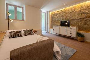 a bedroom with a bed and a tv on a dresser at bnapartments Cedofeita in Porto
