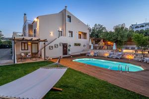 a villa with a pool and a hammock in a yard at Villa Ellovos with Private Pool in Rethymno