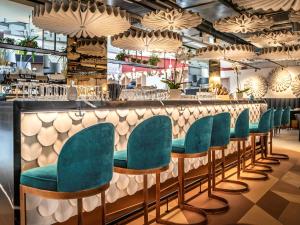 un bar con sedie verdi in un ristorante di ibis Styles Zurich City Center a Zurigo