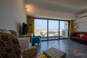 un soggiorno con divano e TV con vista di 2 Bed Apartment w Distant Sea and Country Views a Marsalforn