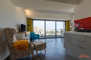 una cucina con due sedie e un soggiorno con vista di 2 Bed Apartment w Distant Sea and Country Views a Marsalforn