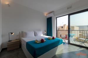 una camera con letto e vista su un balcone di 2 Bed Apartment w Distant Sea and Country Views a Marsalforn