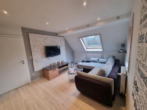 a large living room with a couch and a tv at Ferienwohnung Schneeberg in Stryck