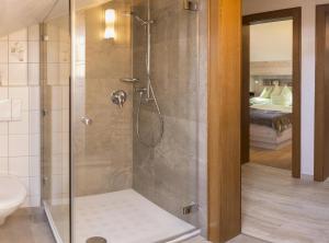 een douche met een glazen deur in een badkamer bij Landhaus Gschwand in Krün