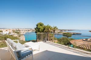 balkon z krzesłem i widokiem na wodę w obiekcie Villa Es Falcons w Porto Cristo