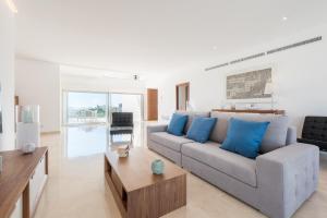 ein Wohnzimmer mit einem Sofa und einem Tisch in der Unterkunft Villa Es Falcons in Porto Cristo