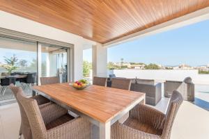 jadalnia na świeżym powietrzu z drewnianym stołem i krzesłami w obiekcie Villa Es Falcons w Porto Cristo