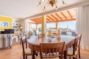une salle à manger avec une table et des chaises et une grande fenêtre dans l'établissement Villa Front a Far, à Portocolom