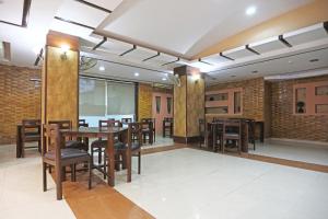 een eetkamer met houten tafels en stoelen bij Tashkent Palace - Budget Friendly - By La Exito Hotels in New Delhi