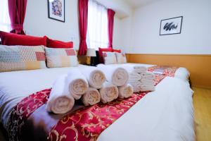 a pile of towels sitting on top of a bed at ケイアイコンホテルズ 新栄301 in Aoichō