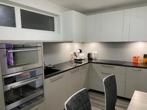 a kitchen with white cabinets and black counter tops at Plein soleil in Martigny-Ville