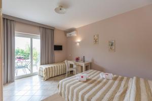 a hotel room with two beds and a balcony at Residenza Borgo Italico in Santa Domenica