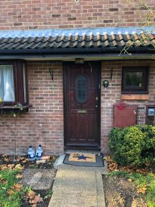 a brick house with a wooden door and a brick at Nice 3-Bed House in Farnham Royal Slough in Slough