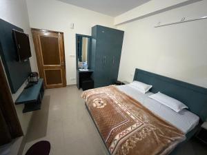 um quarto com uma cama grande e uma cabeceira azul em Ranas B&B em Shimla