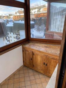 a room with a large window with a view of a snow covered at Grazioso monolocale a Sestriere in Sestriere