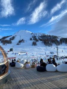a group of people sitting on a snow covered mountain at Grazioso monolocale a Sestriere in Sestriere