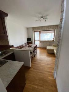a kitchen with a table and a living room at Grazioso monolocale a Sestriere in Sestriere