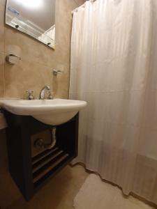 a bathroom with a sink and a shower curtain at Arenas de Colón in Colón