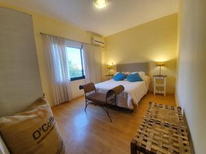 科隆Arenas de Colón的一间卧室，里面有一张床、一把椅子和一扇窗户。