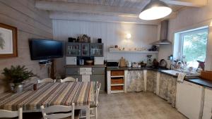 a kitchen with a table and a television in it at Kaszubskie Marzenie in Kartuzy